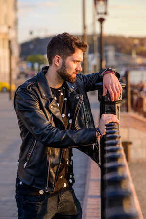 Young man leaning to the fencesの写真素材