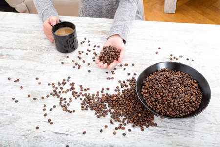 A womans hand at a table with coffee