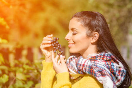 A beautiful woman eating wine grapes on a fieldの写真素材