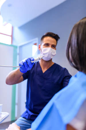 A young Dentist treating a female Patient in the dental studioの写真素材