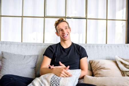 A young handsome man relaxing on the sofa in a loft style apartmの写真素材