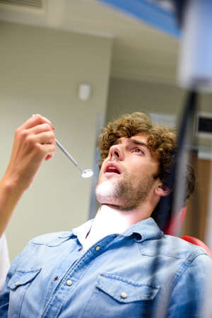 A young man waiting for the beginning of a Dental procedureの写真素材