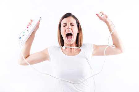 A beautiful young woman screaming with power cables in her handsの写真素材
