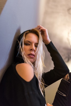 A beautiful young woman sitting on the floor and wearing black clothes.の写真素材