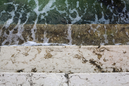 Wet rock stairs flooded by water in sunny environment.の写真素材