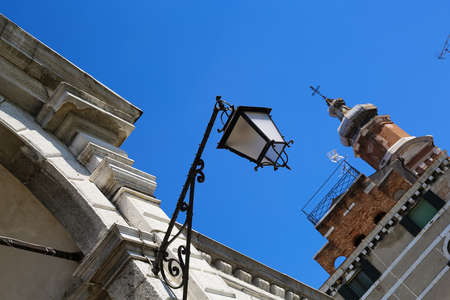 A streetlight lamp on a historic building in Venice, Italy, Europe.の写真素材