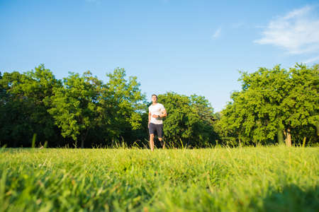 A handsome young man running in a parkの写真素材