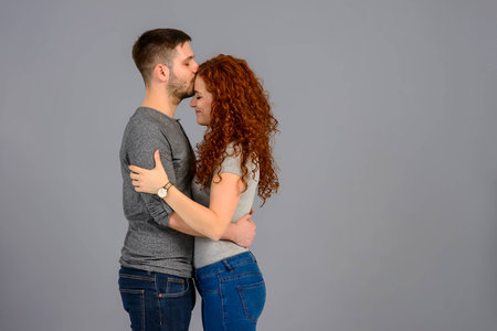 A beautiful young couple hugging and kissing each other in the studio