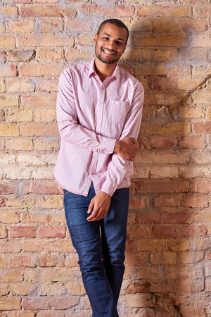 Portrait of a happy handsome young man in a pink shirt.の写真素材