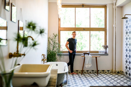 A young handsome man relaxing in a vintage style bathroomの写真素材