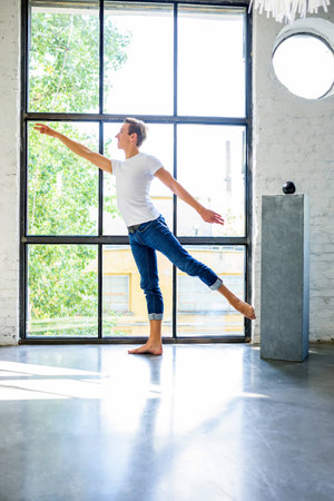 A handsome young male Ballet dancer practicing in a Loft style Apartmentの写真素材