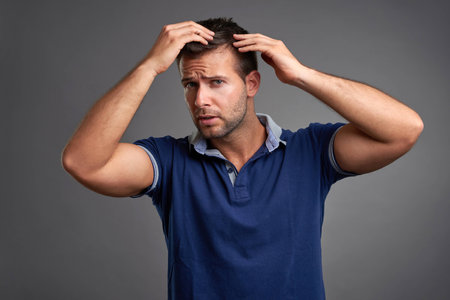Young man checking his hairの写真素材