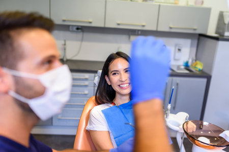 A young Dentist treating a female Patient in the dental studioの写真素材