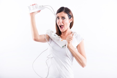 A beautiful young woman screaming with power cables in her hands