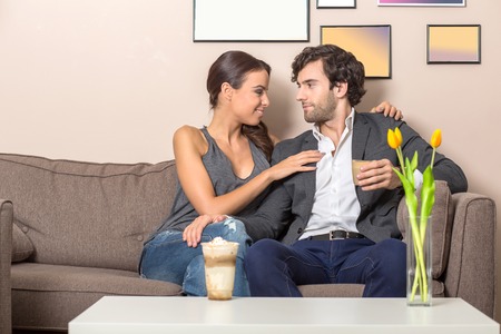 A beautiful young couple on the sofaの写真素材