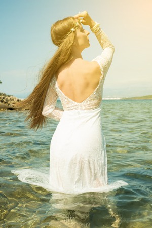 Young woman standing in the oceanの写真素材