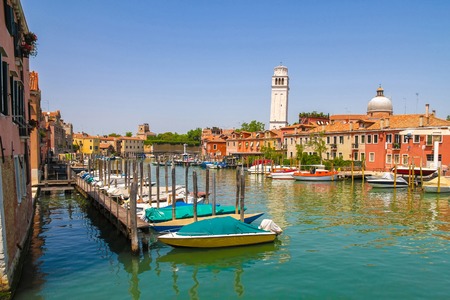 View on the historic architecture and the canal between the ancient buildings in Venice, Italy on a sunny day.の写真素材