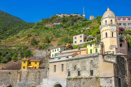 View over the the medieval clock tower of Cinque Terre, Italy with colourful houses on a sunny day.の写真素材