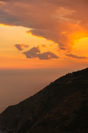 View of the sky during a beautiful orange sunset with clouds over the mountains.の写真素材