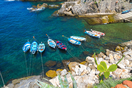 Fishing boats floating on the Mediterranean Sea in the harbour of Cinque Terre, Italy.の写真素材