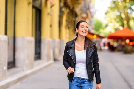 A happy young woman enjoying the autumn in a Central European ciの写真素材
