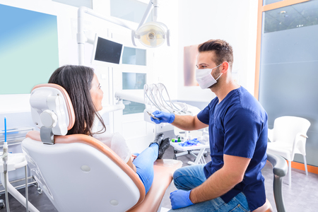 A young Dentist treating a female Patient in a dental practice.の写真素材