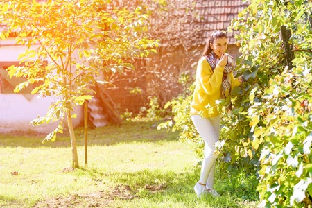 A beautiful woman eating wine grapes on a field