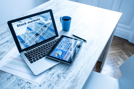 Stock market trading and research software on a Tablet PC with a Laptop computer.の写真素材