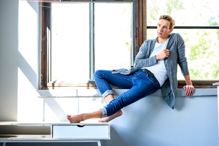 A young handsome male Dancer resting in a modern Loft Apartmentの写真素材