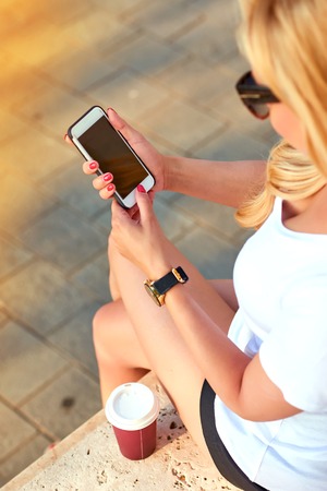 Young woman with a mobile phone in her handsの写真素材