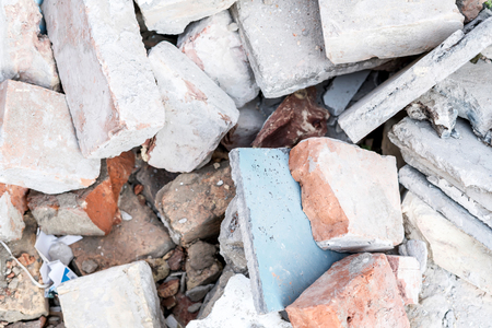 Closeup photo of a pile of broken brick on the ground.