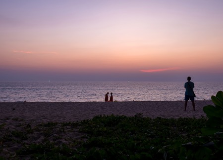PHUKET, THAILAND - CIRCA MARCH 2018: View of the amazing sunset on the beach of Surin with palm leaves in the foreground circa March, 2018 in Phuket, Thailand.のeditorial素材
