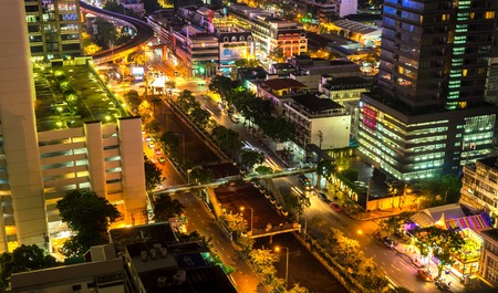 BANGKOK, THAILAND - CIRCA MARCH 2018: View on illuminated houses of the city from a rooftop as traffic passes by at night circa March 2018 in Bangkok, Thailandのeditorial素材