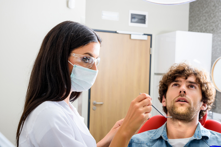 A female Dentist preparing to examine a Patientの写真素材