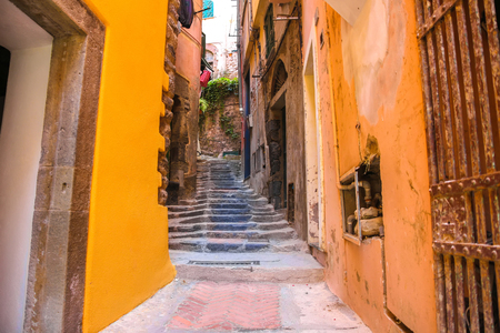 Old rock stairs between the colourful houses in Cinque Terry, Italy on a sunny day.の写真素材