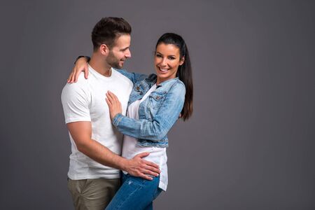 A beautiful young couple hugging and holding each other in the studio
