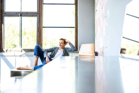 A young handsome male Dancer resting in a modern Loft Apartment