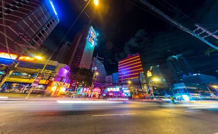 MANILA, PHILIPPINES - CIRCA MARCH 2018: View on daily life on the streets of the city as cars and pedestrians pass by during the night circa March, 2018 in Manila, Philippines.