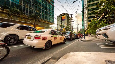MANILA, PHILIPPINES - CIRCA MARCH 2018: View of traffic on the streets of the city as cars and pedestrians pass by during dusk circa March, 2018 in Manila, Philippines.のeditorial素材