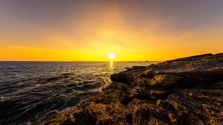 Spectacular view on the rocks of Surin Beach during sunset in Phuket, Thailand.の写真素材
