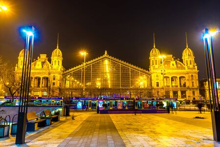 BUDAPEST, HUNGARY - JANUARY 16: View on a historic train station at night as traffic and public transport passes by on January 16, 2016 in Budapest, Hungary.のeditorial素材