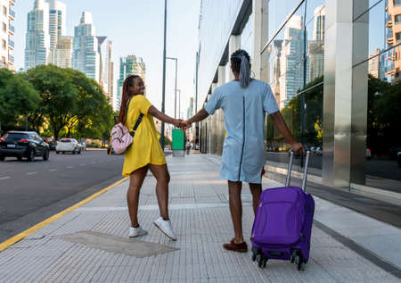 A young couple with luggage traveling in the big city during summer.の写真素材