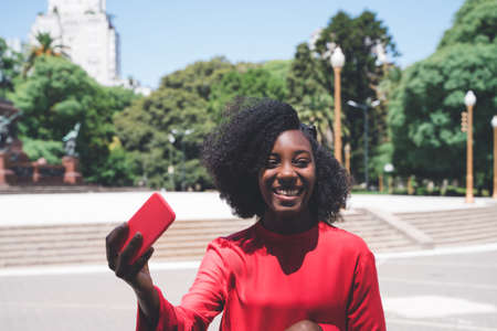 A black young woman taking a selfie in the city.の写真素材