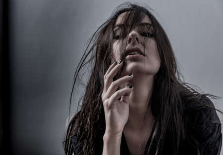 Dark mood sensual portrait of a beautiful woman while lying on a sofa.