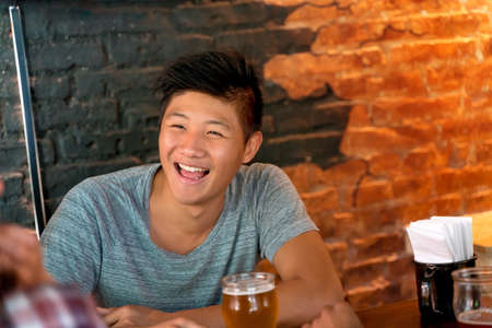 A handsome laughing asian man having fun.の写真素材