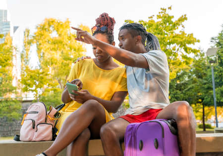 A travelling couple getting orientation with a app in the city.