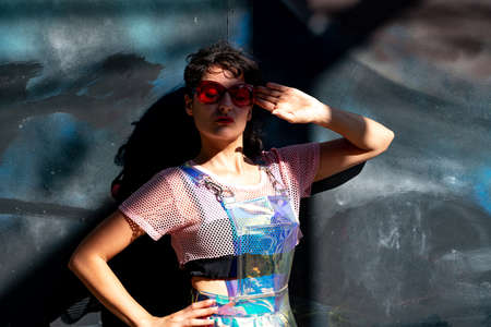 Young woman wearing extreme clothes posing at the grey background.の写真素材