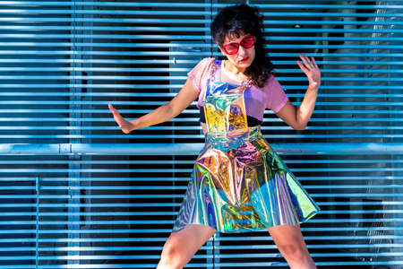 Crazy woman wearing surrealistic outfit posing at grey iron gratings.