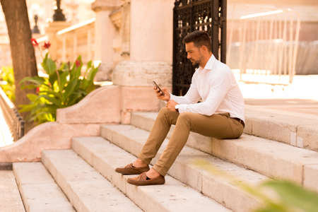 A businessman on the stairs using his smartphoneの写真素材