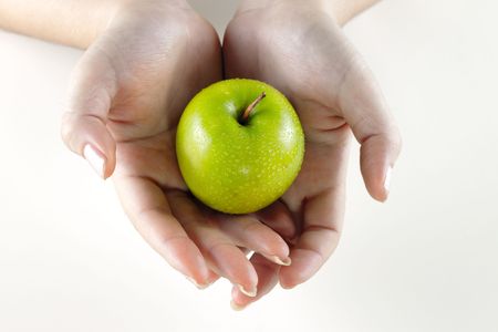 A woman's hands holding a green appleの写真素材